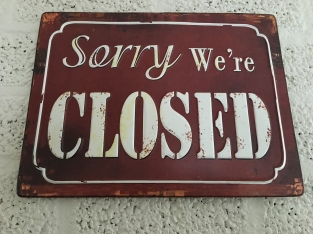 Metalen bord met prachtig geschilderde tekst: Sorry we're closed.
